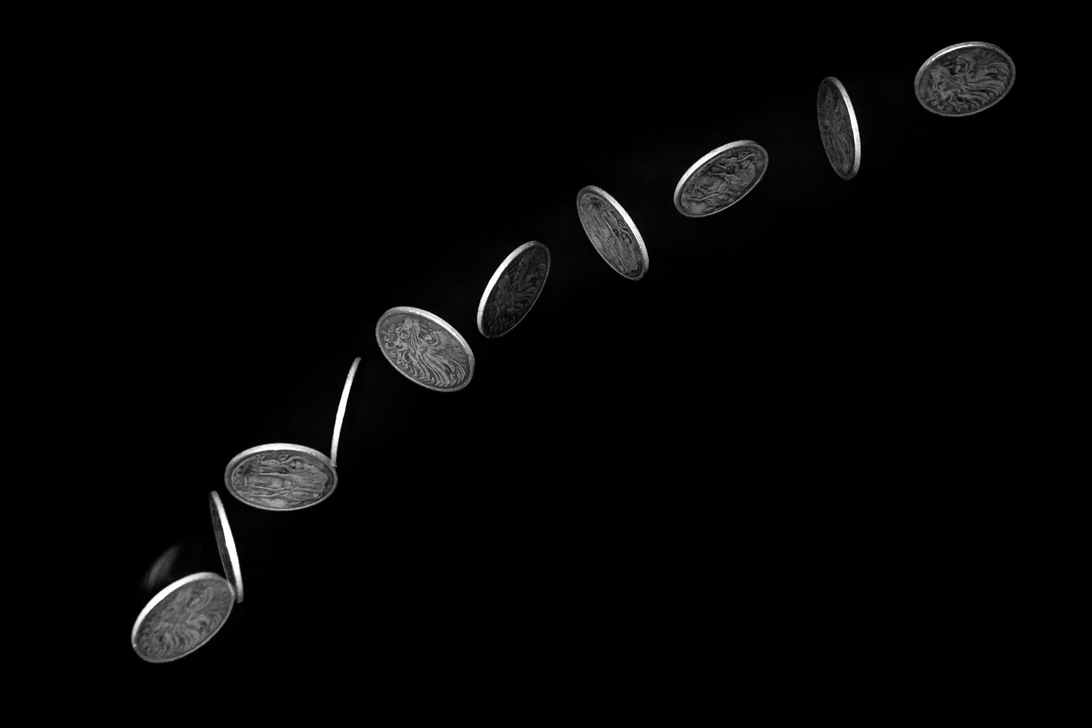 Coin flipping against black background