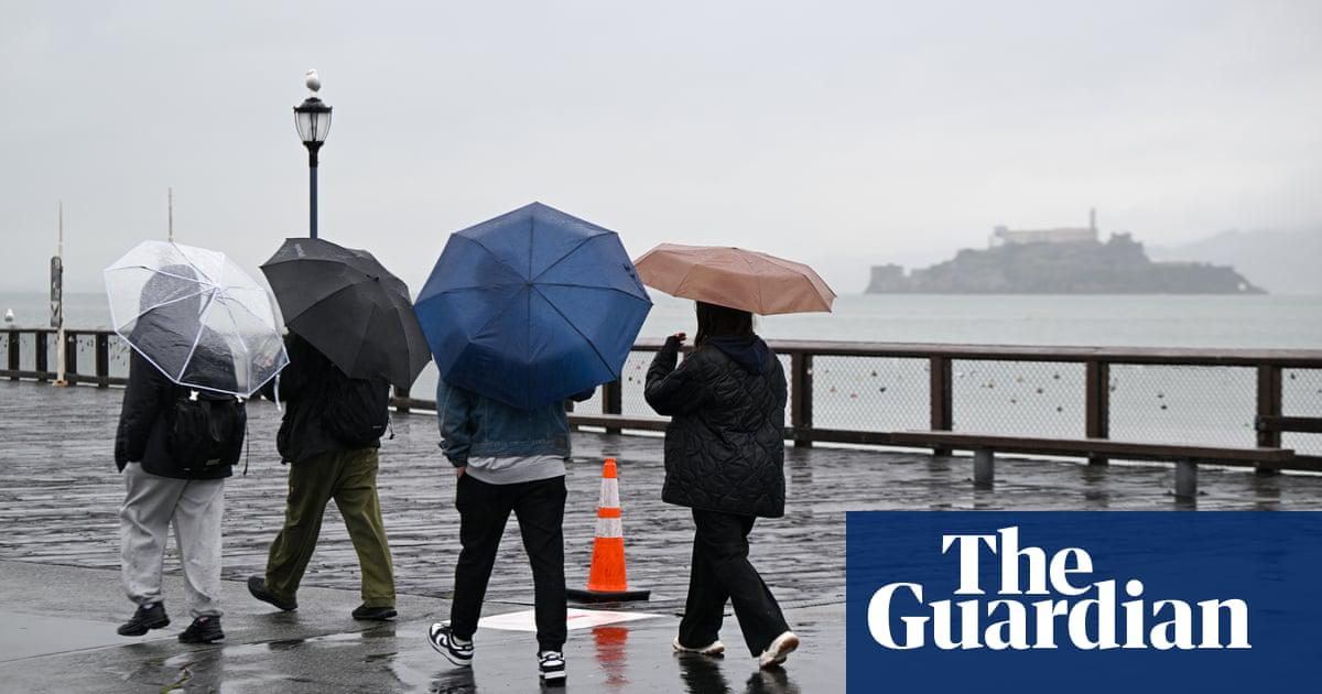 People with umbrellas near Pier 39 on Fisherman's Wharf, San Francisco.