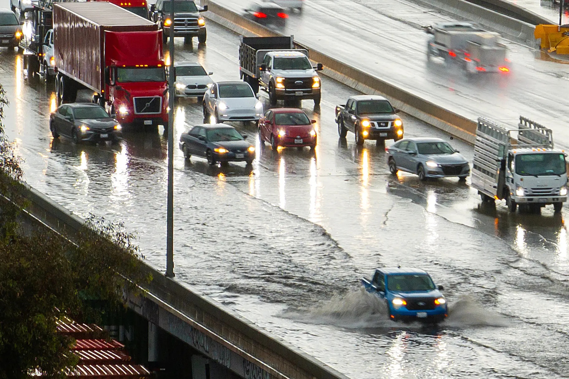 Cars pass through a flooded stretch of Interstate 880 in Oakland, Calif., on Monday.