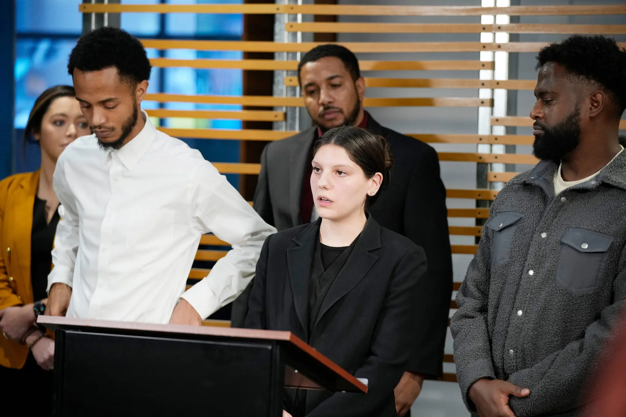 Bailey Alexander, center, speaks alongside Willis Small IV, left, and Yekalo Wedewihet at a news conference in 2023. They were three of six bystanders injured during a police shooting in Denver in 2022. Christ Whitney, a lawyer, is at the center rear.