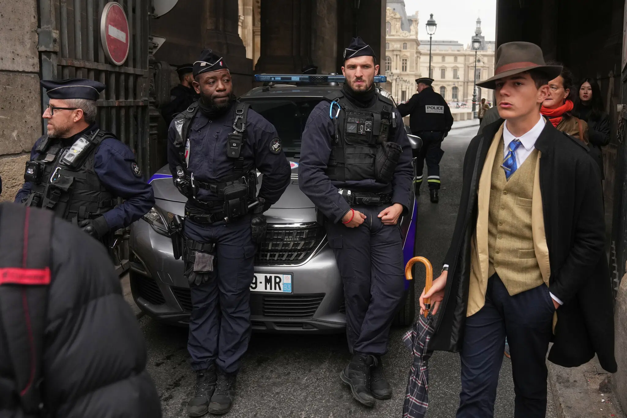 In a scene that confused many people on social media, a sharply-dressed man walked near police officers blocking an entrance at the Louvre on Sunday.