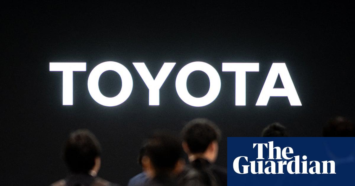 People walk past the logo of Toyota during the press day of the Japan Mobility Show in Tokyo on Wednesday.