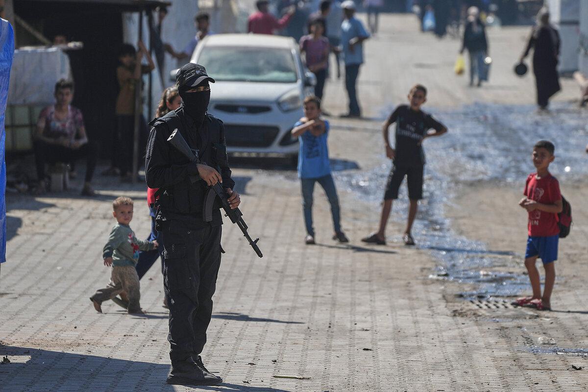 An armed member of Hamas stands at the site where the militant group, along with Egyptian workers and machinery, are searching for the bodies of Israeli hostages in the Gaza Strip, Oct. 28, 2025.