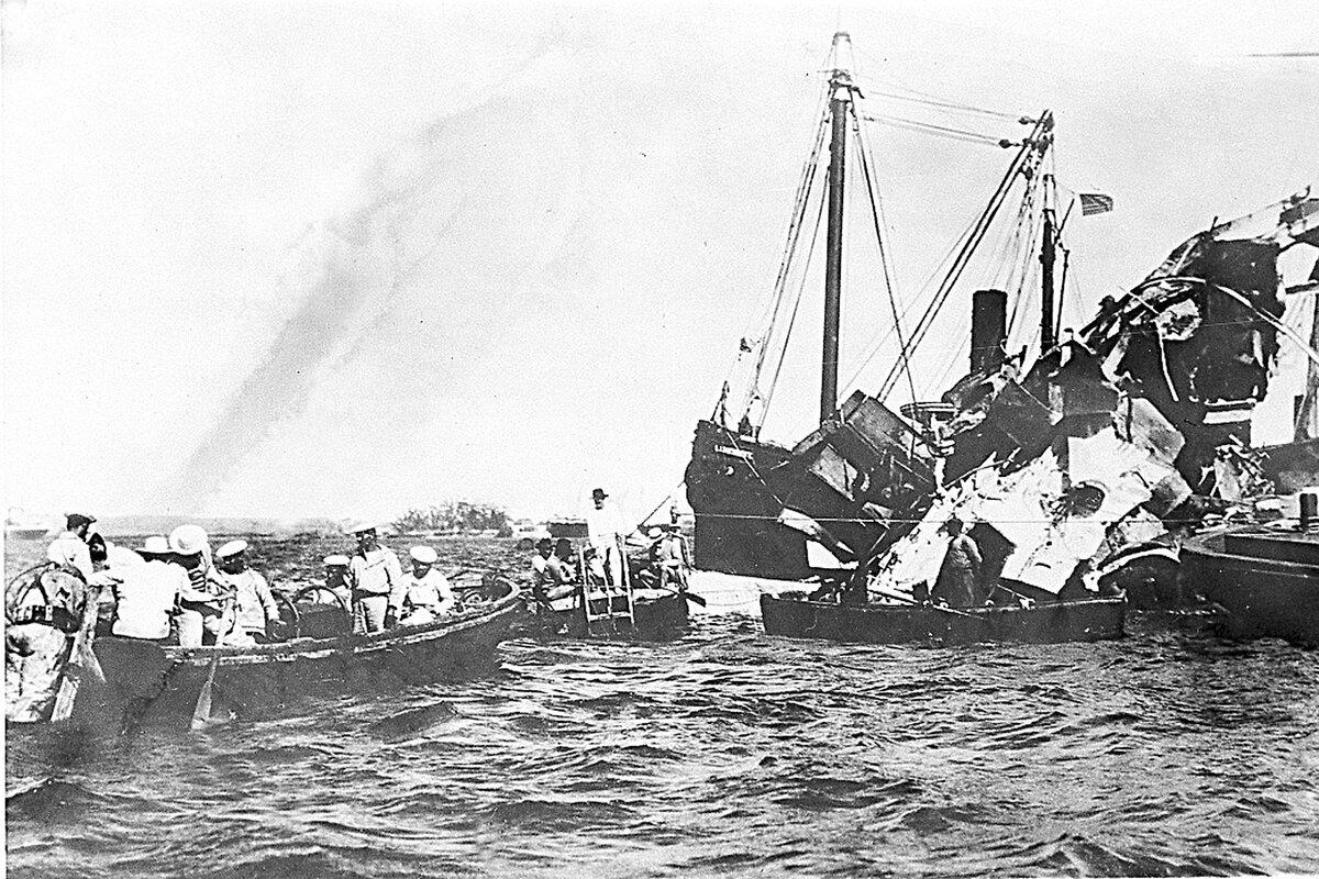 Lifeboats rescue surviving crewmen of the wrecked USS Maine, whose sinking in Havana Harbor prompted the United States to launch the Spanish-American War.