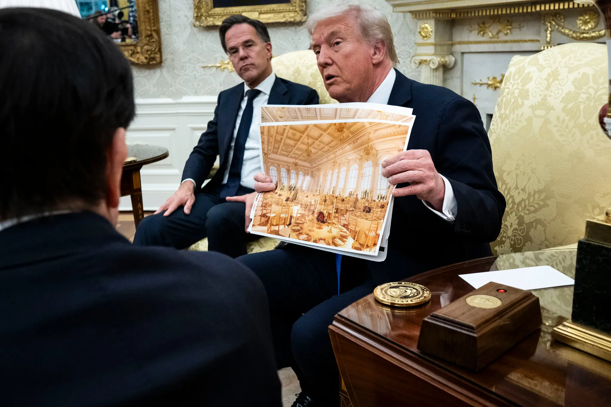 President Trump holding photos of the ballroom he’s building at the White House.