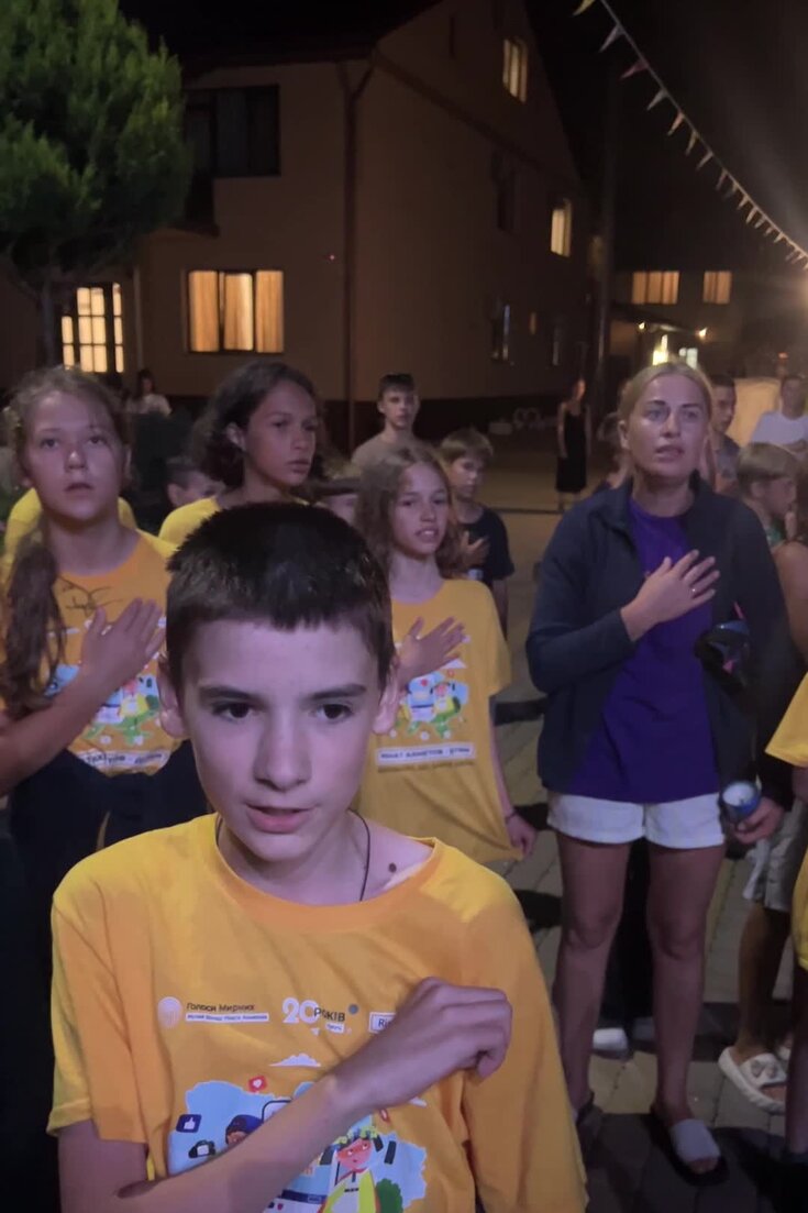 Artem Miz singing the Ukrainian national anthem with his fellow campers at a party in August in the Zakarpattia region of Ukraine.