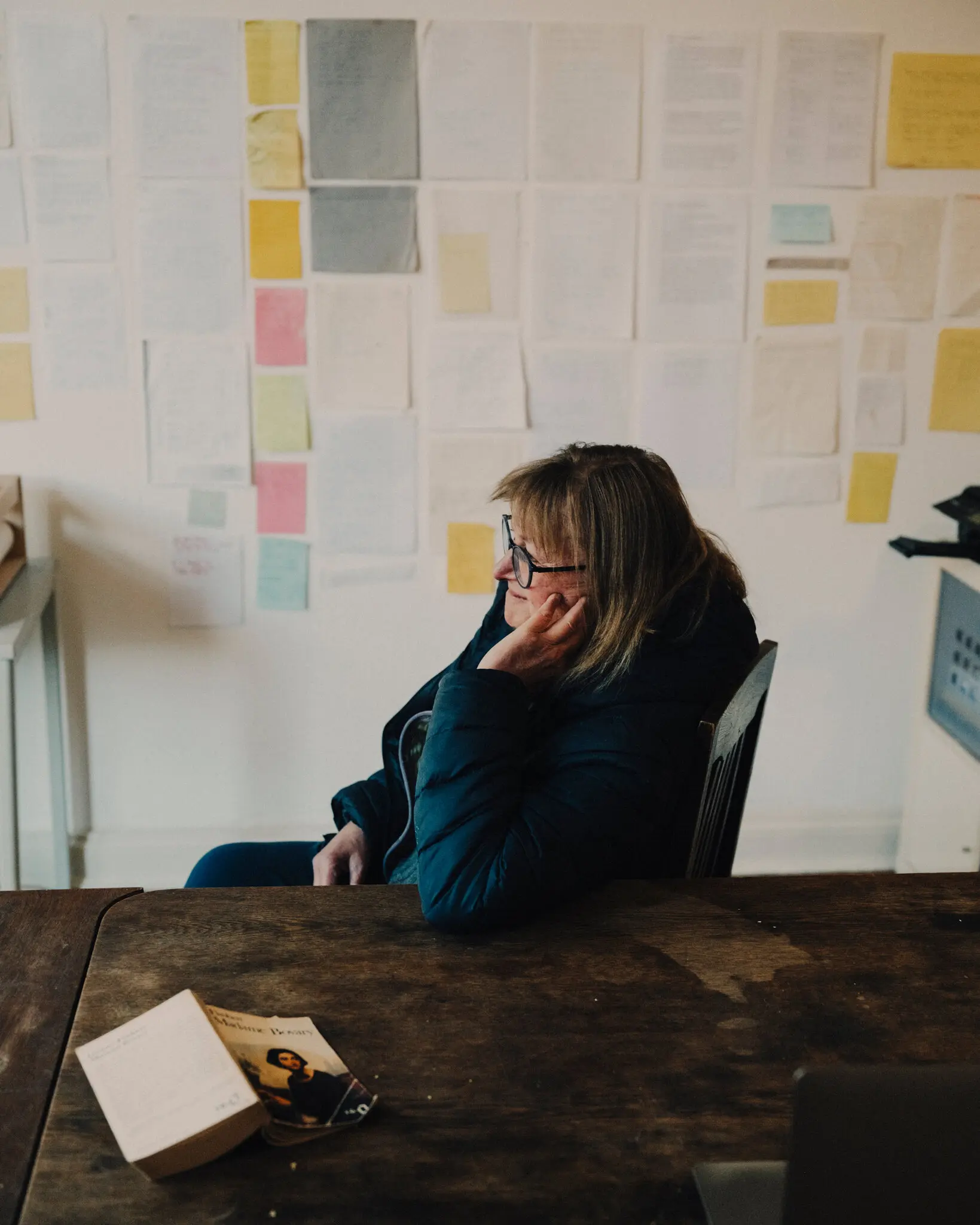 Helen DeWitt at home in Berlin, with pages from works in progress behind her.
