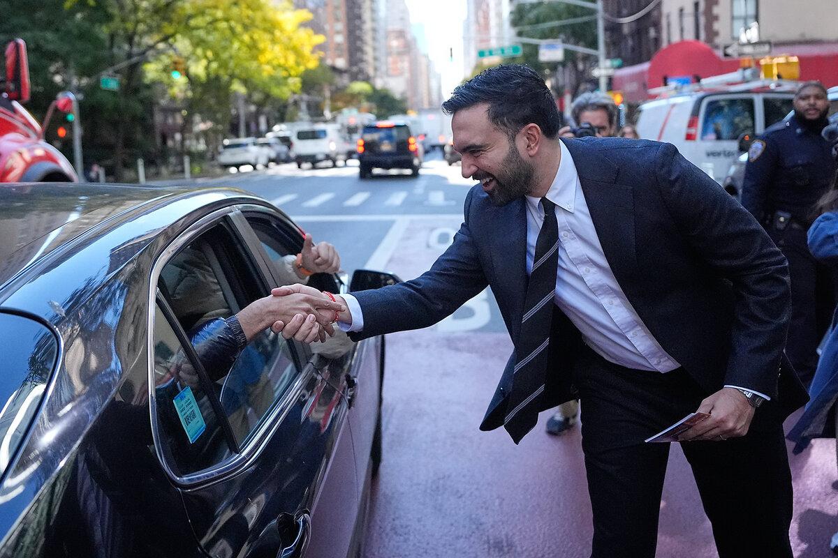 New York City mayoral candidate Zohran Mamdani greets people in a car while surrounded by reporters in New York, Oct. 27, 2025. 