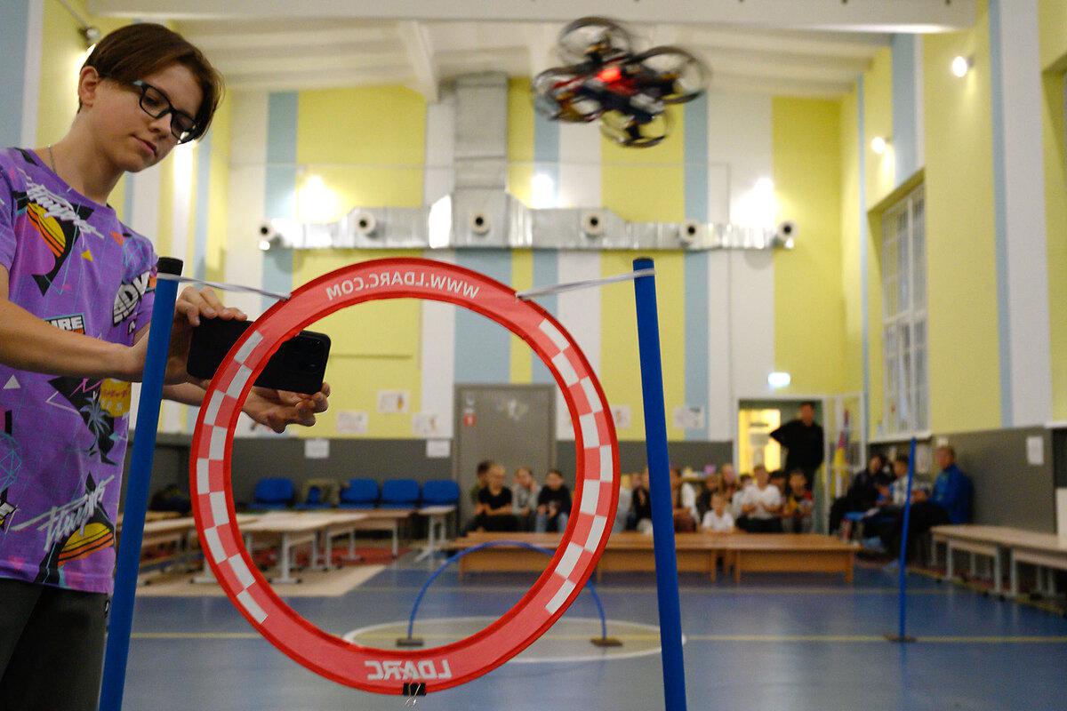 A student photographs a small drone as it is flown through an obstacle course as Oleh Azarov, an instructor of “Defending Ukraine” classes, teaches students to operate them, in a sports gymnasium in Bucha, Ukraine, Sept. 17, 2025.