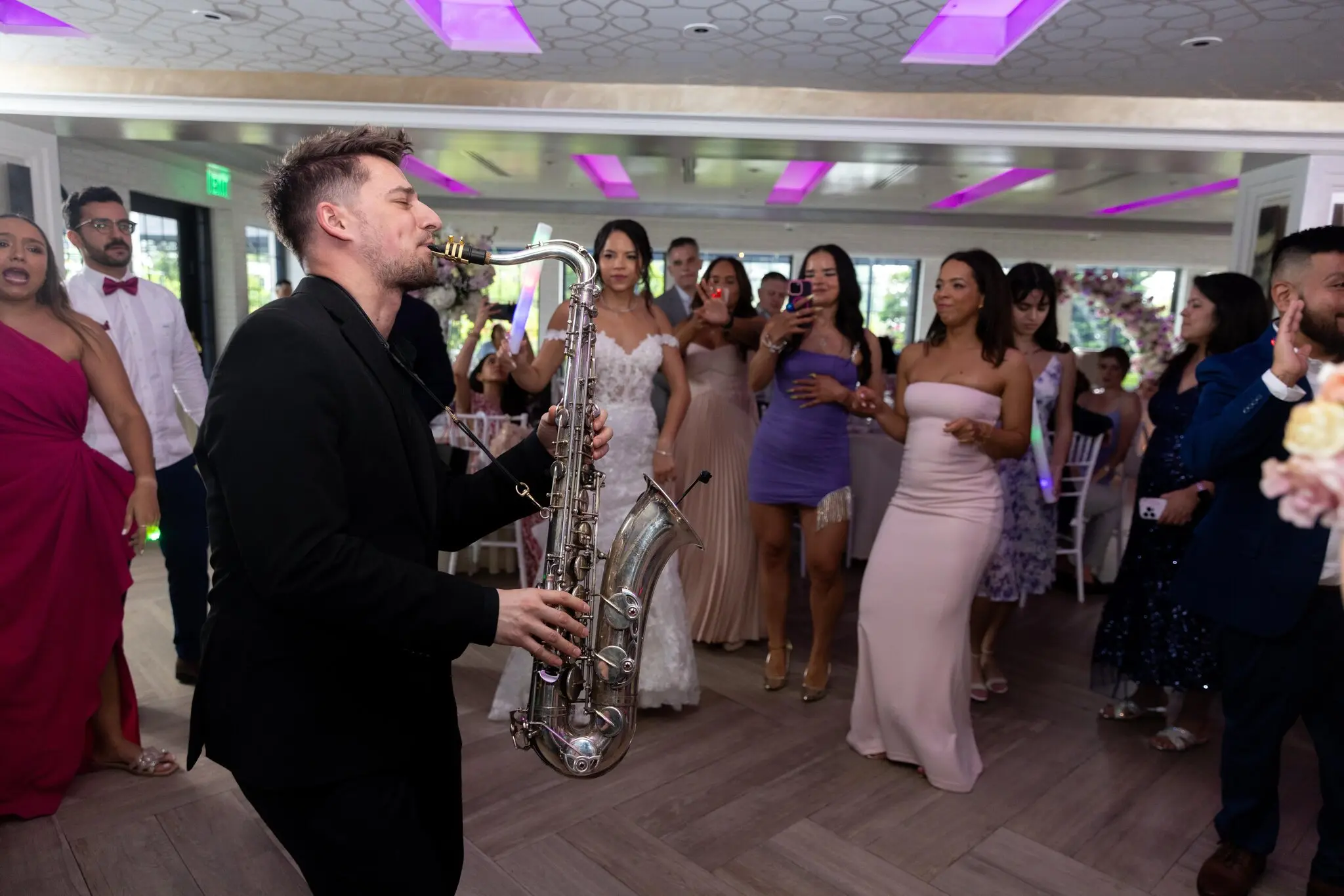 Eliny Almonte Rodriguez, in the bridal gown, had to convince her husband, Roberto Hinojosa, to agree to a saxophonist for their June wedding. “Now he just brags to everybody how awesome it was.”