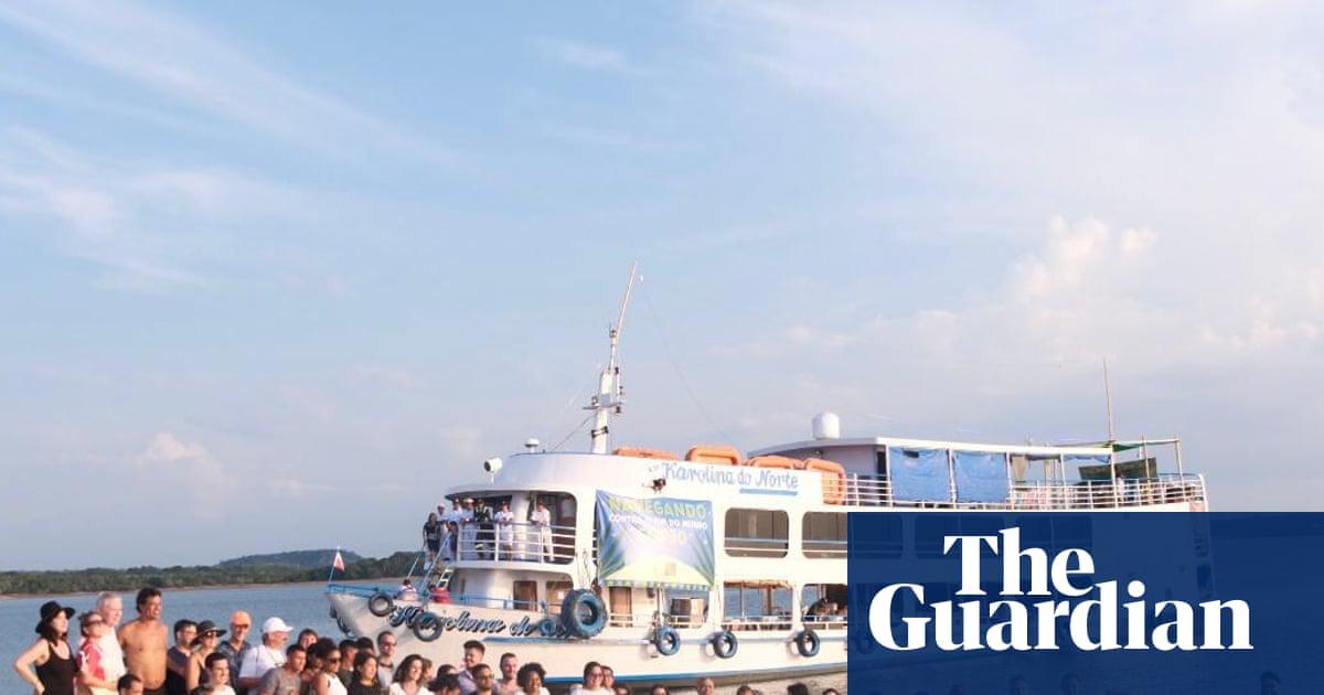 Climate campaigners from the Karolina do Norte boat pose for group photo after a traditional inauguration ceremony on the shore of the Amazon river.
