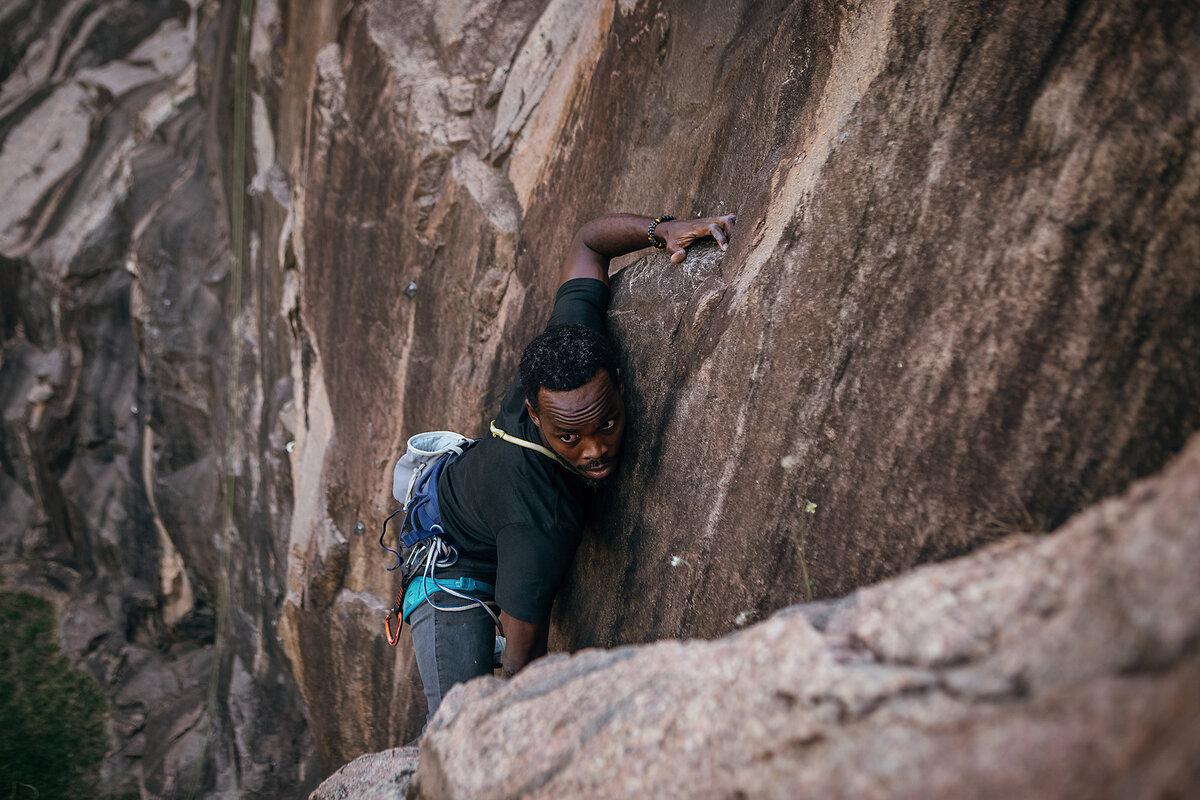 CLIMB MANAGEMENT: Albert Abayo leads a route known as “On the Eggs” at Muyenga quarry in Kampala, Uganda. He and other club members are working to increase community exposure to rock climbing.
