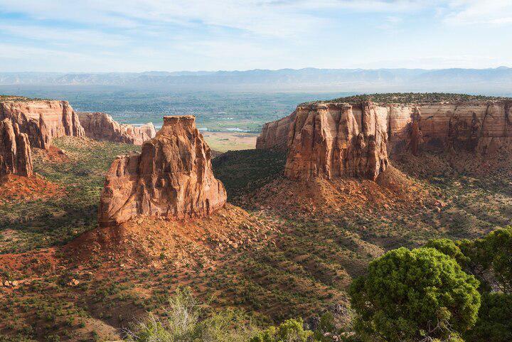 Located near Grand Junction, Colorado, the Colorado National Monument, or “mini-Grand Canyon,” has six distinct canyons and 43 trails. Its red rocks, towering formations, and sheer cliffs are visible along the scenic Rim Rock Drive.