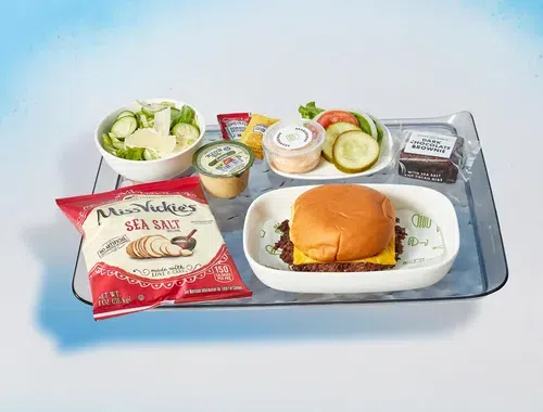 A tray of airline food featuring a Shake Shack burger entree.