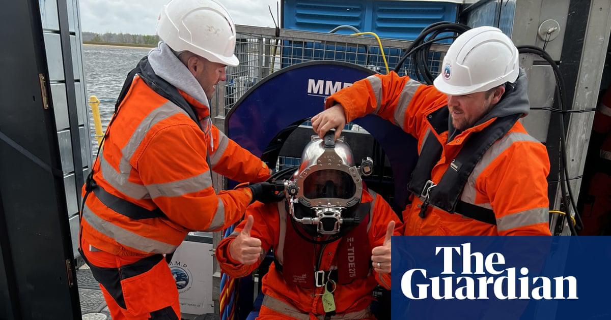 Workers from Glenfield Invicta prepare to dive below the surface of Queen Mother reservoir near Heathrow airport.