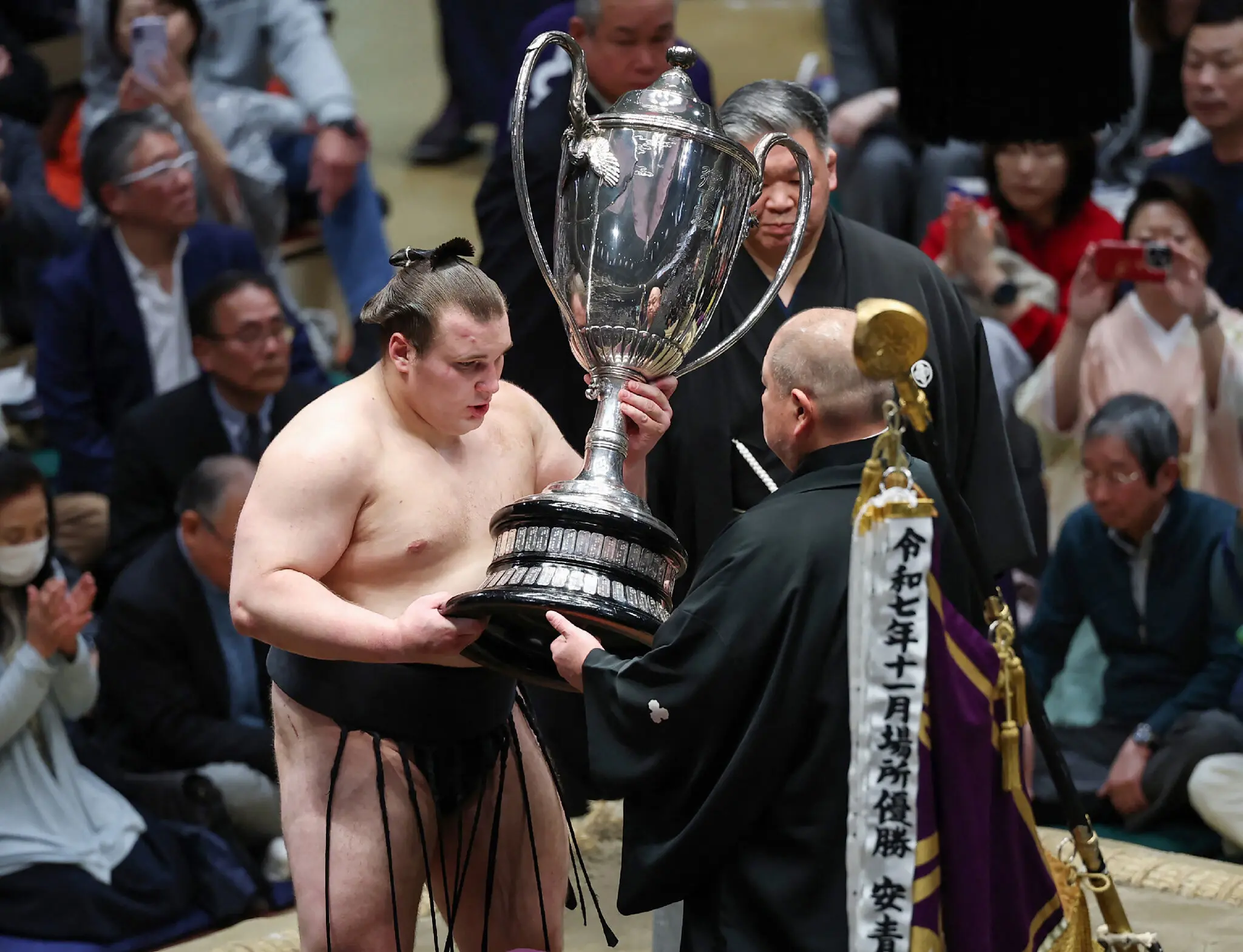 The Ukrainian Danylo Yavhusishyn, also known by his Japanese ring name, Aonishiki Arata, receiving his trophy at the New Year Grand Sumo Tournament in Tokyo on Sunday.