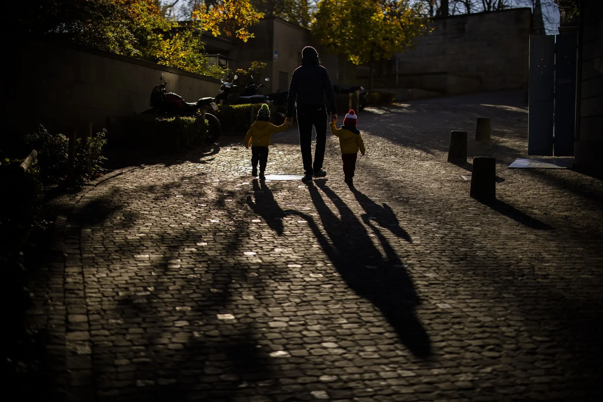 A man walking with two children in Zurich. Switzerland will vote in June on a proposal to cap its population at 10 million through 2050.