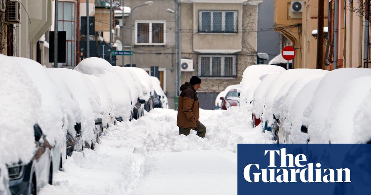 A man wades through knee-deep snow as he attempts to cross a Bucharest street on Wednesday.